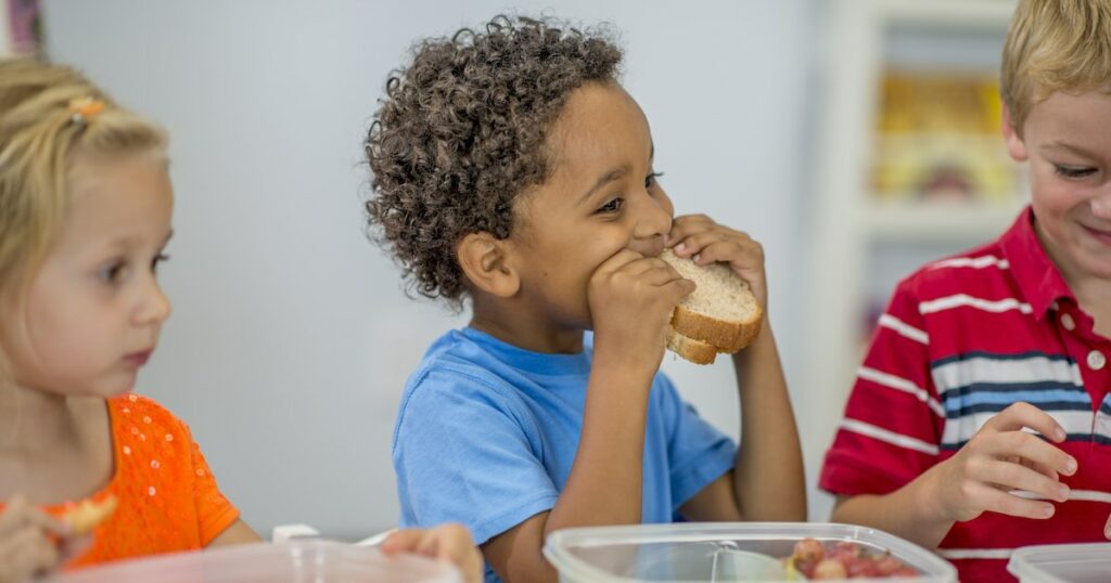 Little boy eating his lunch at school